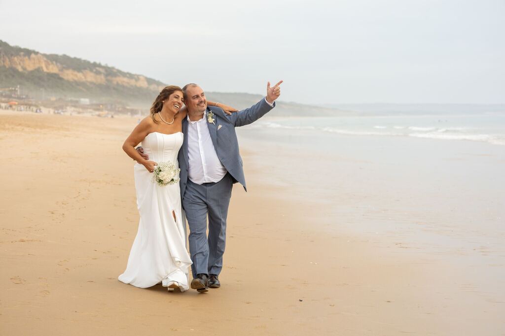 Noivos a caminhar na praia
