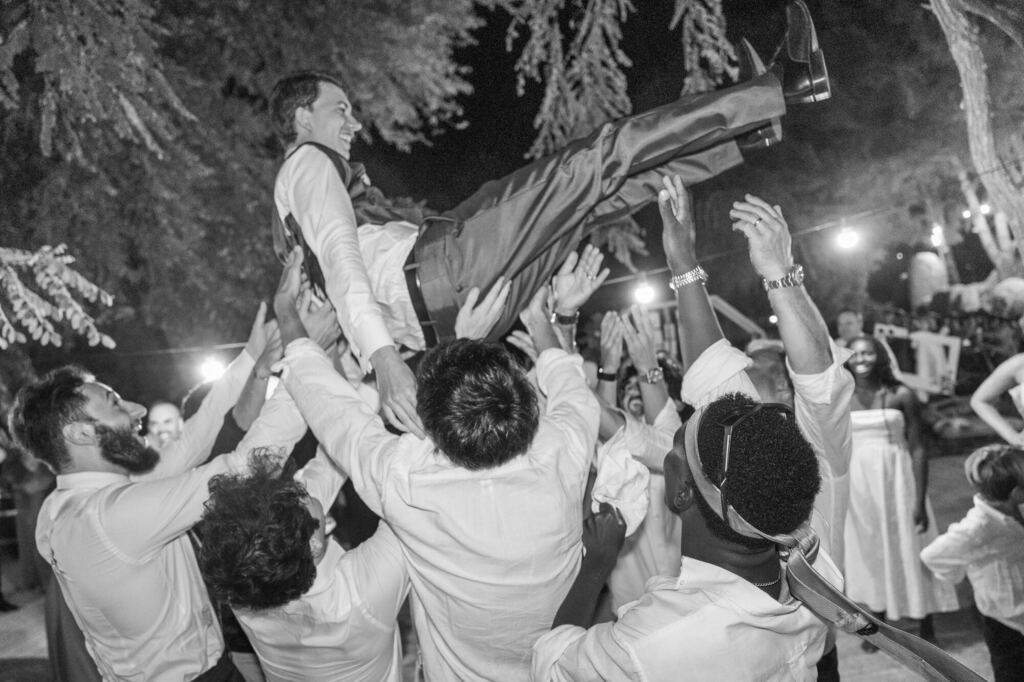 Amigos a lançar o noivo ao ar na festa