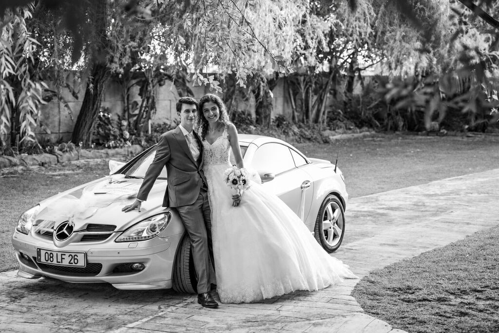 Noivos junto ao carro, a preto e branco